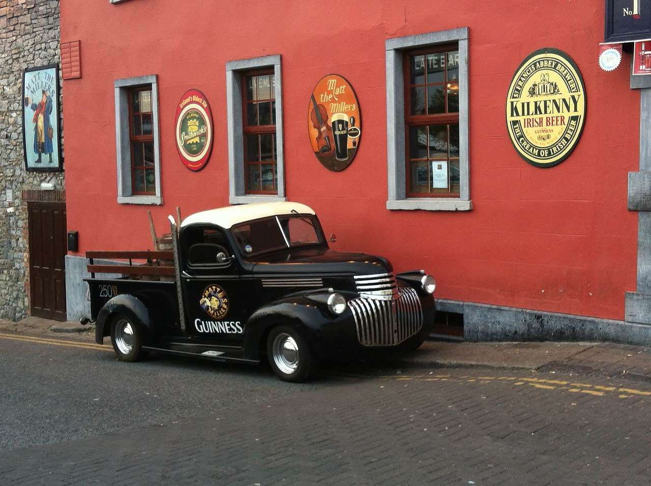 City breaks from Cork, Ireland, Guinness car outside a pub.